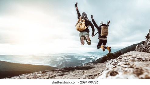 Couple traveler on mountain summit enjoying nature view with hands raised over clouds - Sport, travel business and success, leadership and achievement concept