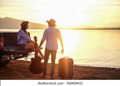 couple traveler playing guitar and watching sunset near the lake background  the mountain.Asia tourist enjoying for sunset during holiday - Powered by Shutterstock