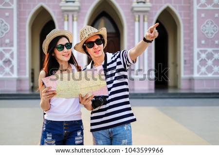 Couple of traveler using local map together for go to destination in the city. tourist couple have a good time on vacation background is the church. Happy family go to travel on holiday.