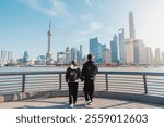 Couple traveler visiting in Shanghai, China. Tourists sightseeing Shanghai view of Lujiazui on The Bund of Shanghai. landmark and popular for tourism attractions. Vacation concept