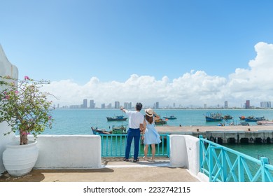 Couple traveler visiting at Son Tra marina. Tourist with blue dress and hat traveling in Da Nang city. Vietnam and Southeast Asia travel concept