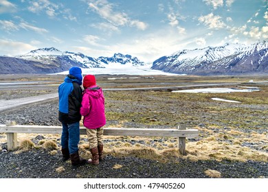 Couple Traveling, A Couple Wearing Colorful Jackets Watching The Great View Of Snow Mountains And Glaciers In Iceland
