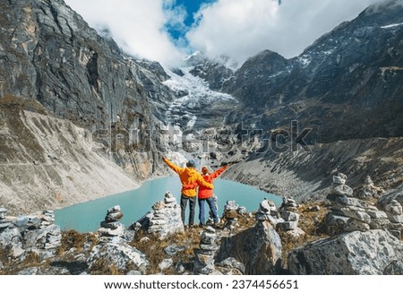 Couple trekkers dressed bright jackets on the rock enjoying a glacier falling in high altitude Sabai Tso glacial lake cca 4350m. Makalu Barun National Park, Mera peak climbing route, Nepal. Foto stock © 