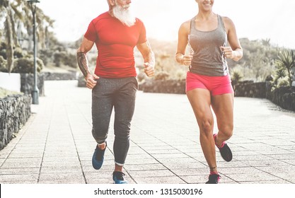 Couple Of Trendy Fitness Friends Running Outdoor At Sunset - Joggers People Training At Evening Time After Work - Jogging, Healthy Lifestyle And Sport Concept - Focus On Feet Shoes