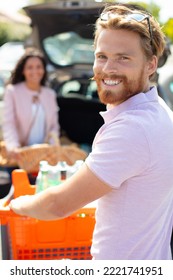 Couple With A Trolley In A Supermarket Car Park