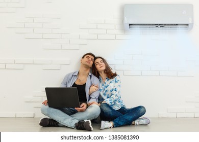 couple turning on air conditioner during the summer heat while using laptop