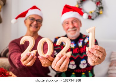 Couple Of Two Happy And Cheerful Senior And Mature People Showing At The Camera And Holding Wooden Numbers Of The New Year 2021 - Celebrating The New Year And New Life And Christmas At Home