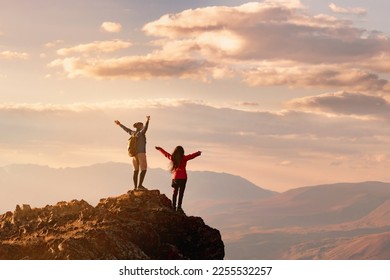 Couple two happy hikers stands with open arms at sunset view point high in mountains - Powered by Shutterstock