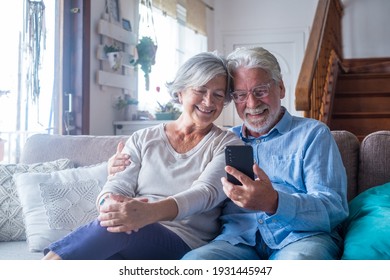 Couple Of Two Old And Mature People At Home Using Tablet Together In Sofa. Senior Use Laptop Having Fun And Enjoying Looking At It. Leisure And Free Time Concept