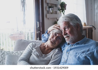 Couple Of Two Sad And Depressed Old People Sitting On The Sofa At Home Looking Outside The Window. Lockdown And Quarantine Lifestyle Indoor.