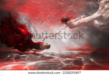 couple two women swim underwater, girl fantasy mermaid river nymph, long dress tail silk fabric fluttering. Woman fairy greek goddess drowns under water. Fashion model posing in pool red light clothes