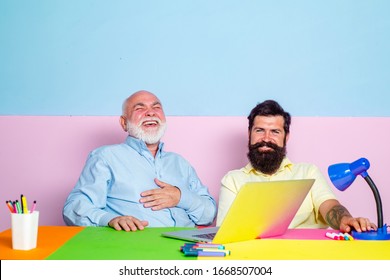 Couple Of Two Young Office Workers Laugh Looking At Laptop Screen. Happy Diverse Colleagues Laugh Watching Funny Content On Computer