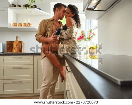 A couple in unbuttoned clothes hugging passionately in the kitchen, holding a jar of vitamins or pills. Emphasizes the importance of responsible use of medications or vitamins for self-care.