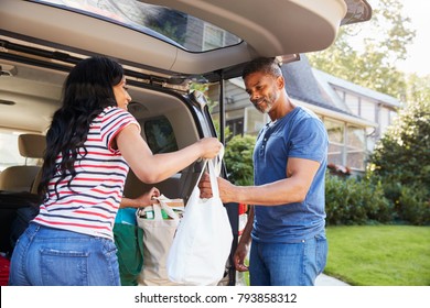 Couple Unloading Shopping Bags From Car