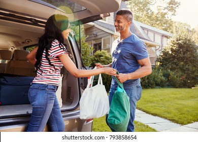 Couple Unloading Shopping Bags From Car