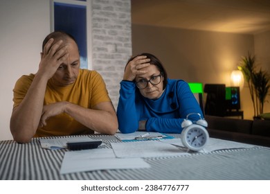 Couple upset headache depressed from family cost got higher  holding receipts from supermarket with calculator by rising grocery prices and surging cost as an inflation financial crisis.