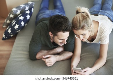 Couple Using Cell Phone In Their New Home 
