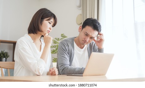 A couple using a computer in the living room
