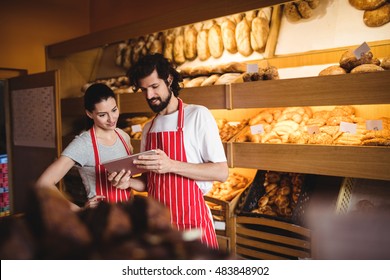 Couple using digital tablet in bakery shop - Powered by Shutterstock