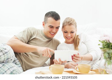 Couple using a digital tablet at home