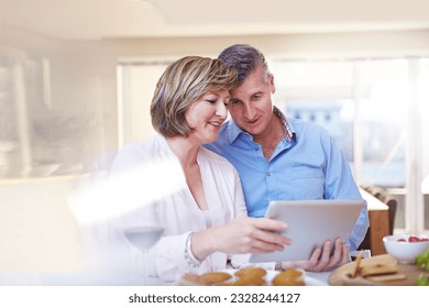 Couple using digital tablet in kitchen