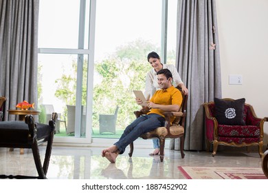 Couple using digital tablet in the living room - Powered by Shutterstock