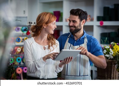 Couple using digital tablet and looking at each other in the flower shop - Powered by Shutterstock