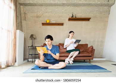 Couple using digital tablet on sofa at home