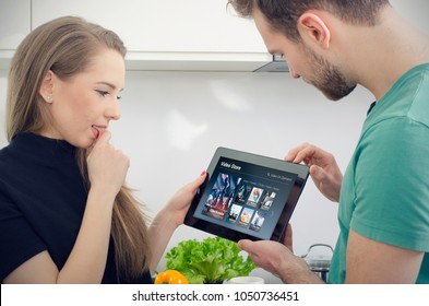 Couple using digital tablet for watching movie on VOD service. Video On Demand television internet stream multimedia concept