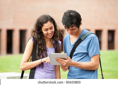 Couple Using A Tablet Computer Outside A Building