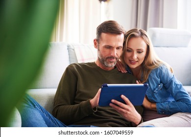 Couple using a tablet in living room 