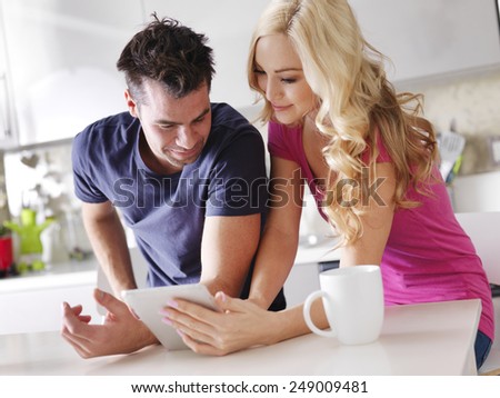 couple using tablet pc to shop online in kitchen