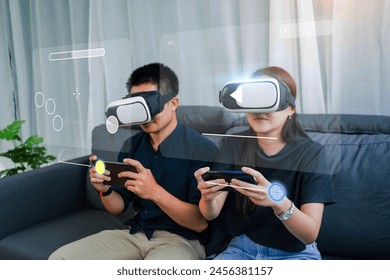Couple using VR virtual reality headset interacting with an application system browsing the internet and entertainment system at home living room. - Powered by Shutterstock - Get 15% off with code: PIKWIZARD15