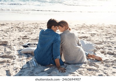 Couple, vacation or beach trip sitting on blanket for picnic or relaxing on seashore getaway. Love, man and woman together happy in nature by ocean for romantic date, sunset or holiday in California - Powered by Shutterstock