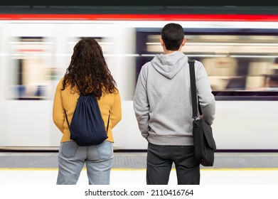 Couple waiting the train in the platform of subway station. Public transport concept. - Shutterstock ID 2110416764