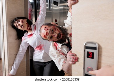 Couple Of Walkers Leaving Elevator To Attack People In Business Office, Walking Dead Horror Apocalypse With Devil Possessed Zombies . Eerie Dramatic Corpses Brain Eating Monsters At Workplace.