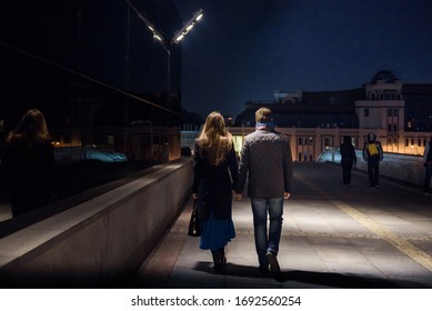 Couple Walking At Alley In Night Lights. Happy Man And Woman Holding Hands With Tender Under Yellow Lantern In Night Lights Of The City