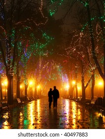 Couple Walking At Alley In Night Lights