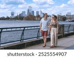 Couple walking along Canary Wharf riverfront in London