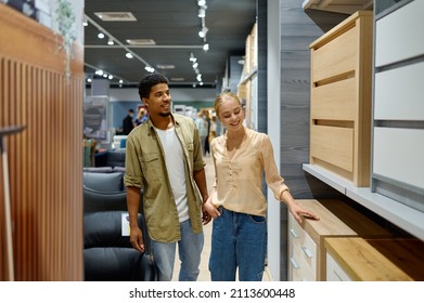 Couple Walking Along Shopping Arcade With Furniture