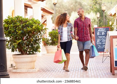 Couple Walking Along Street With Shopping Bags