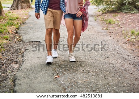 Couple walking arm in arm. A shot of feet in shoes. Modern gumshoes. Comfortable shoes.