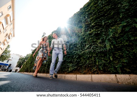 Couple walking in The city of Denia, Spain. Young happy couple walking and holding each other hand in a summer day. Young man and woman in dress on vacations