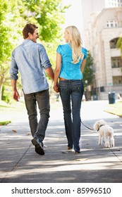 Couple Walking With Dog In City Street