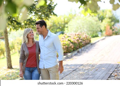 Couple walking hand in hand in park - Powered by Shutterstock
