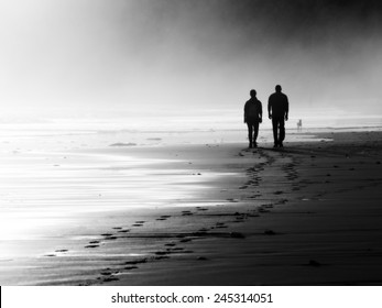 couple walking on beach. Black and white