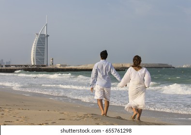 Couple Walking On A Beach Is Dubai