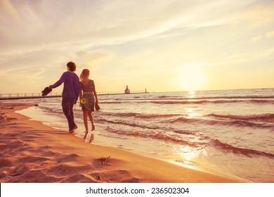 Couple Walking On The Beach At Sunset