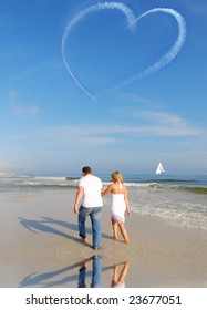 Couple Walking On Beach Under Heart Skywriting