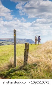 A Couple Walking On Cliff Top On The South West Coastal Path Network, Dorset, UK